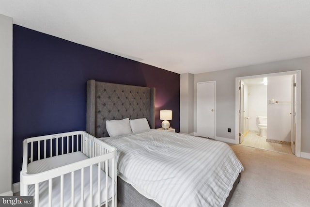 bedroom featuring carpet, baseboards, and ensuite bathroom