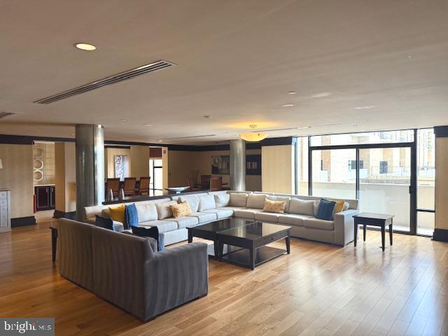 living area featuring plenty of natural light, wood finished floors, and visible vents