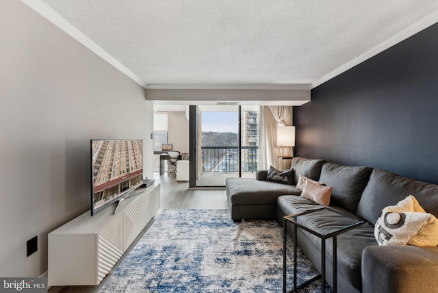 living area with visible vents, a textured ceiling, wood finished floors, and ornamental molding