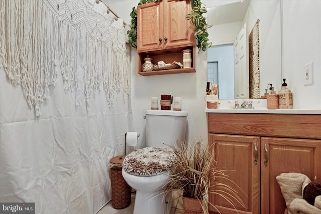 bathroom featuring toilet, vanity, and a shower with curtain