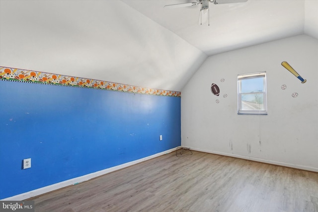 additional living space with baseboards, a ceiling fan, lofted ceiling, and wood finished floors