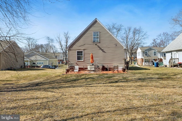 rear view of house featuring a yard, a residential view, and a patio