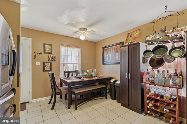 dining space with light tile patterned floors, baseboards, and ceiling fan