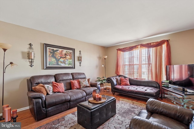 living area with baseboards and wood finished floors