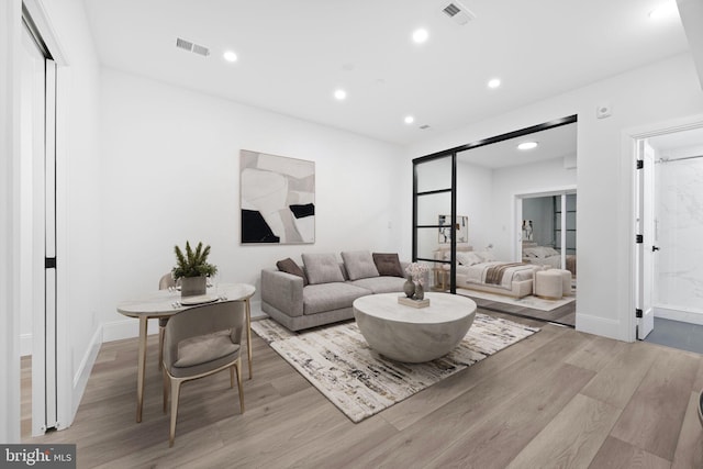 living room featuring recessed lighting, visible vents, and wood finished floors