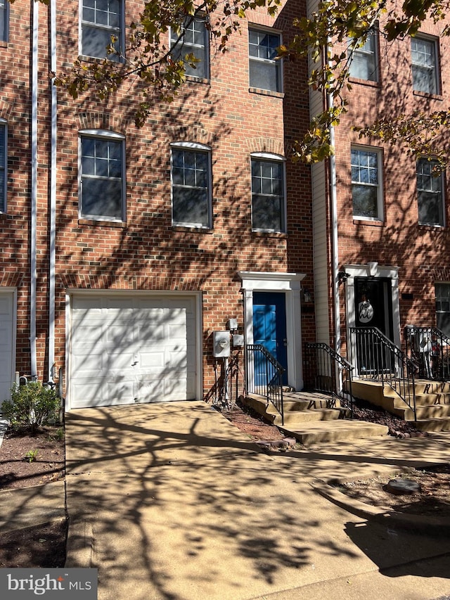 view of front of home with brick siding, concrete driveway, and an attached garage