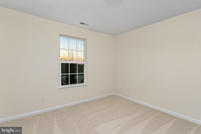 carpeted empty room featuring visible vents and baseboards