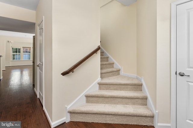 stairway featuring baseboards and wood-type flooring