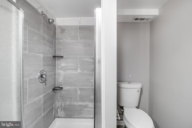 bathroom featuring toilet, a stall shower, and visible vents