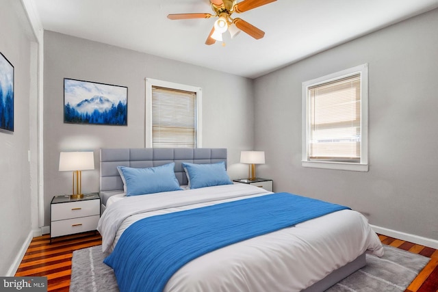 bedroom with wood finished floors, a ceiling fan, and baseboards