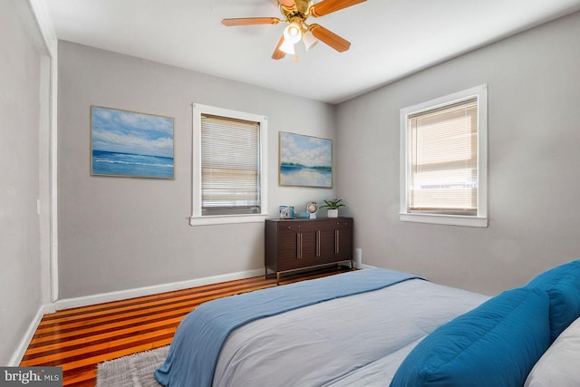 bedroom featuring baseboards, a ceiling fan, and wood finished floors