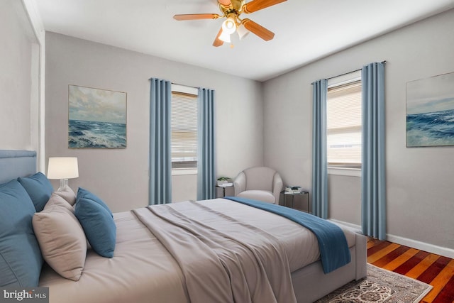 bedroom with ceiling fan, baseboards, and wood finished floors