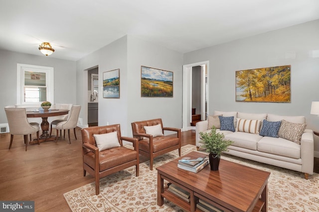 living area featuring light wood-type flooring and visible vents