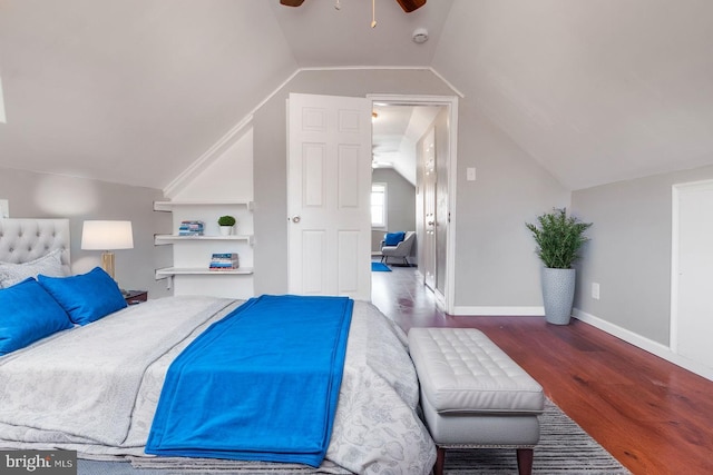 bedroom featuring lofted ceiling, wood finished floors, and baseboards