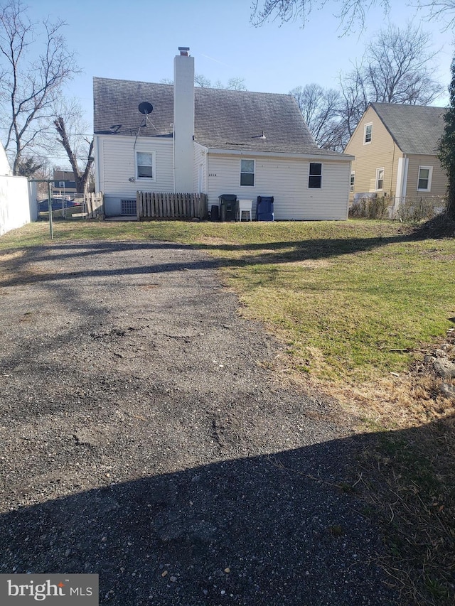 6114 Belwood St, District Heights, MD 20747 - back of property featuring fence, a lawn, and a chimney