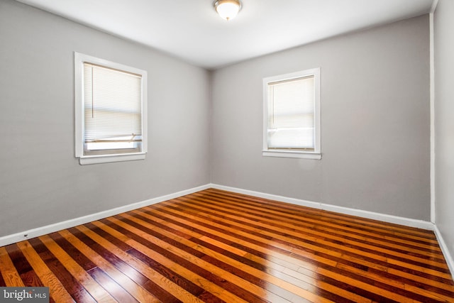 empty room featuring wood-type flooring and baseboards