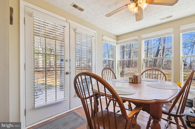 dining space featuring a wealth of natural light, visible vents, and wood finished floors