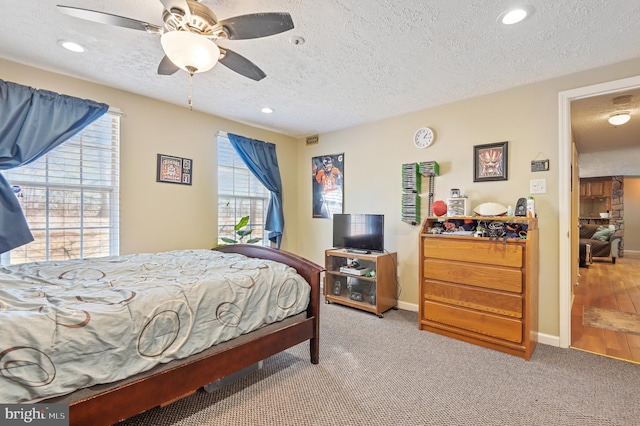 bedroom with baseboards, carpet floors, recessed lighting, ceiling fan, and a textured ceiling