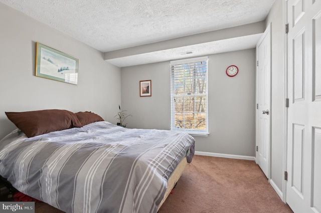 bedroom featuring visible vents, baseboards, carpet floors, and a textured ceiling