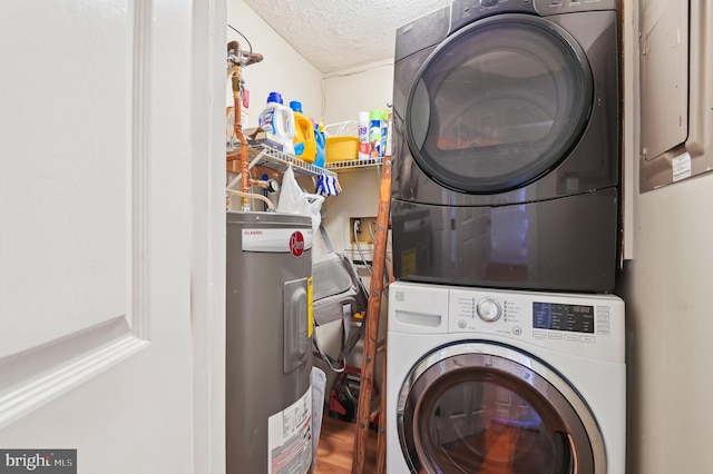 laundry room with a textured ceiling, stacked washer and clothes dryer, water heater, and laundry area