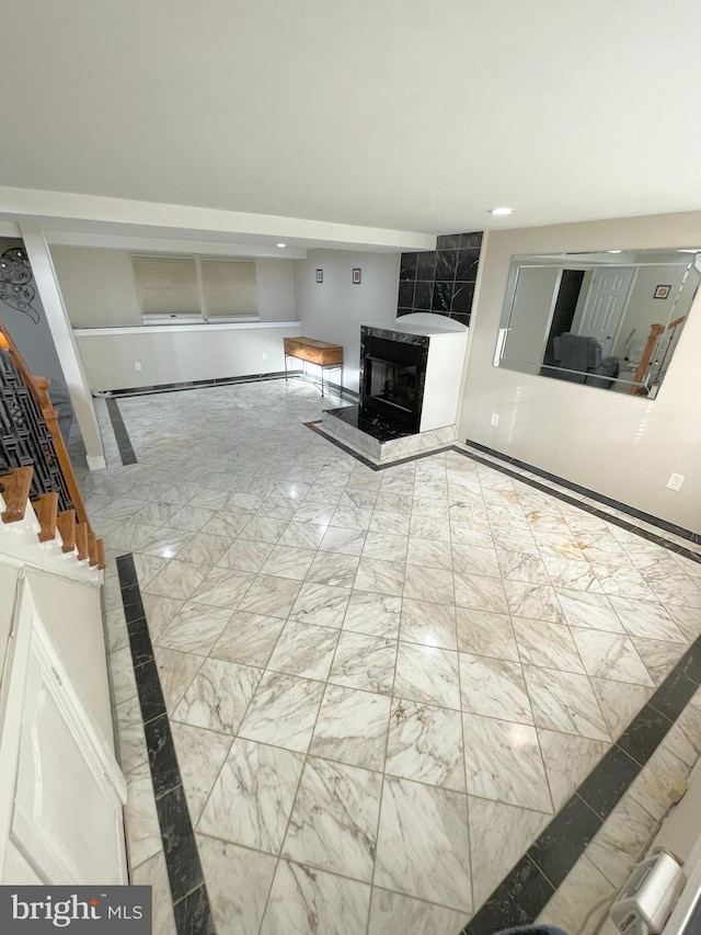 unfurnished living room with recessed lighting, a fireplace, marble finish floor, baseboard heating, and stairway