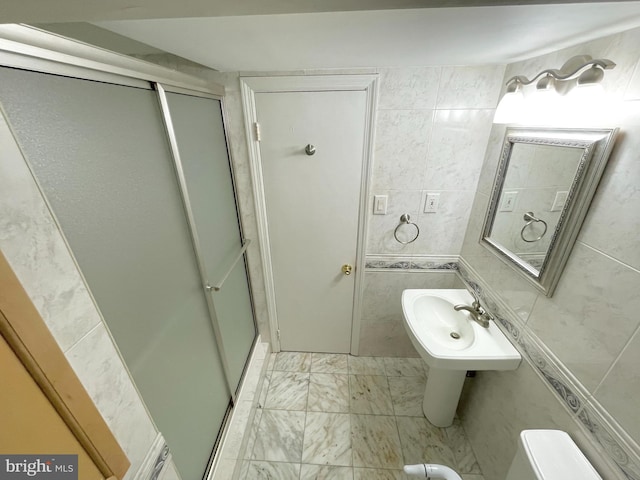 full bath featuring toilet, marble finish floor, a shower stall, and tile walls