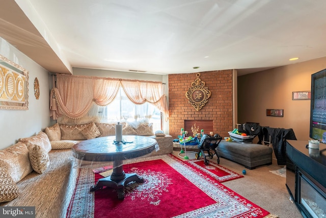 living area featuring a brick fireplace, visible vents, and carpet flooring