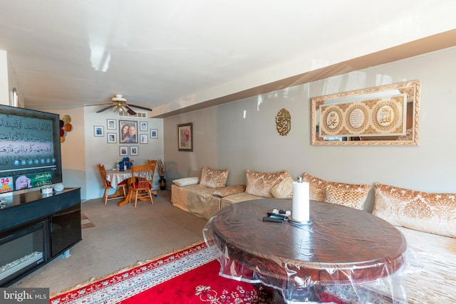 living area featuring carpet flooring and ceiling fan