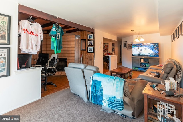 living room with an inviting chandelier, carpet, beamed ceiling, and wood walls