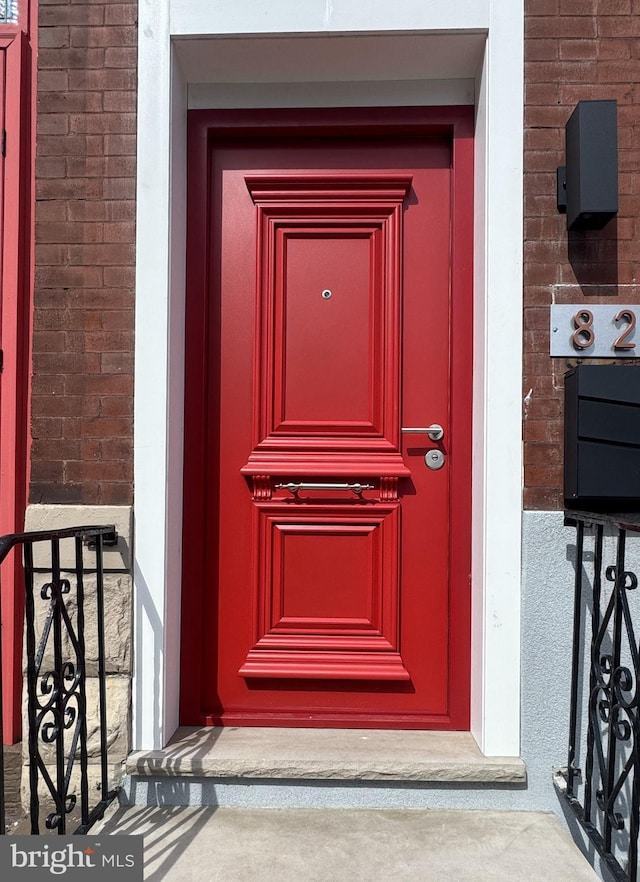 view of exterior entry featuring brick siding