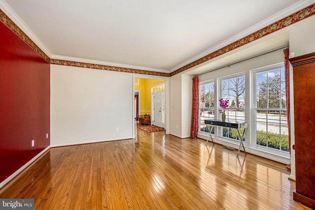 unfurnished room with crown molding, baseboards, and hardwood / wood-style flooring