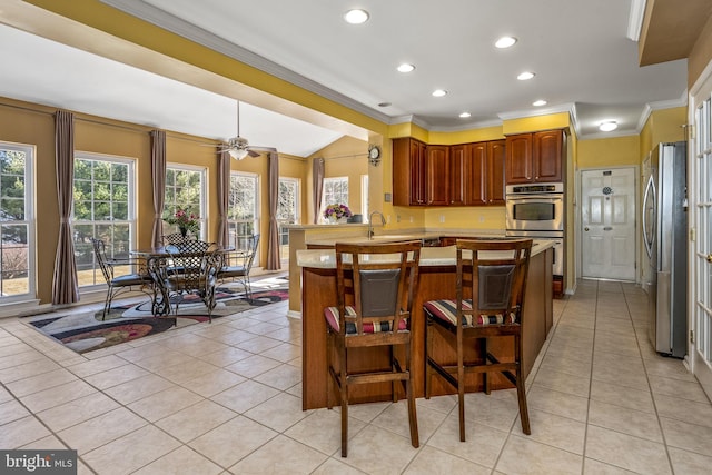 kitchen with light tile patterned floors, stainless steel appliances, light countertops, and vaulted ceiling