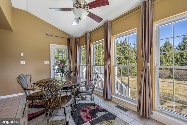 dining space with visible vents, a ceiling fan, baseboards, light tile patterned floors, and lofted ceiling