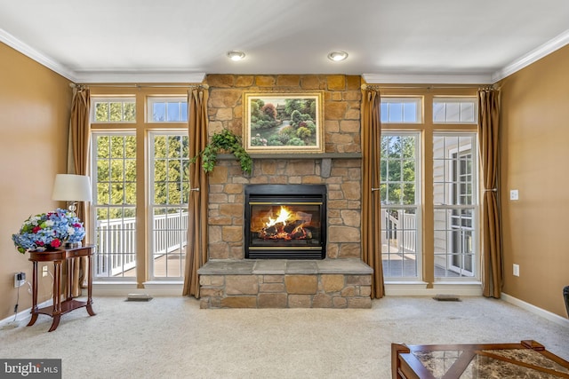 carpeted living room featuring a stone fireplace, crown molding, and baseboards