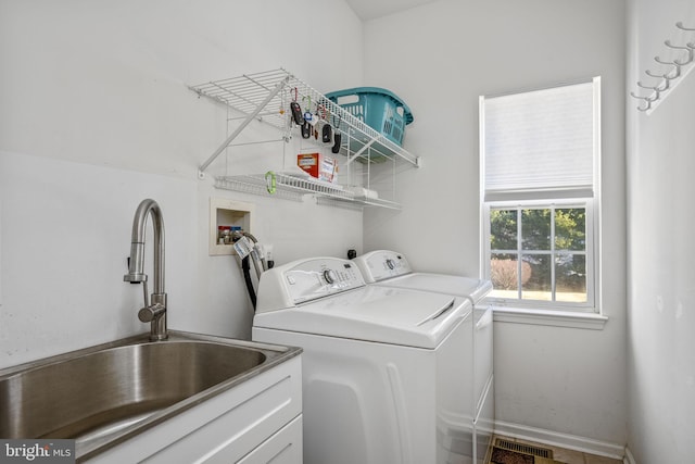 laundry area with washing machine and clothes dryer, laundry area, visible vents, and a sink