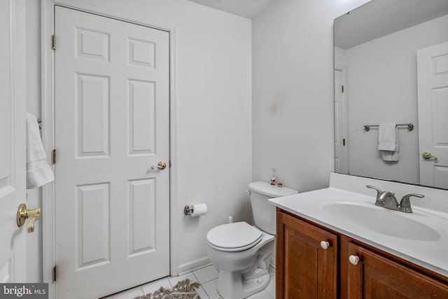 half bathroom with tile patterned floors, toilet, and vanity