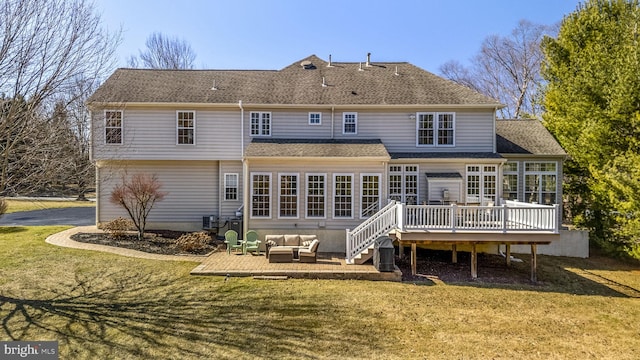 back of house with roof with shingles, a lawn, an outdoor hangout area, a garage, and a deck