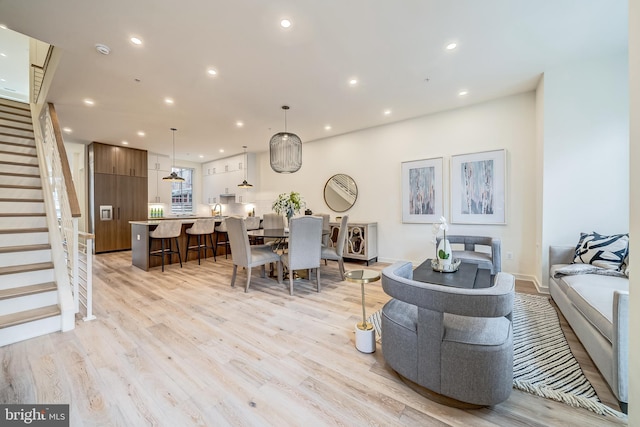 living room with stairs, recessed lighting, and light wood-style floors