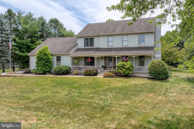 view of front of property featuring a front lawn, covered porch, and roof with shingles