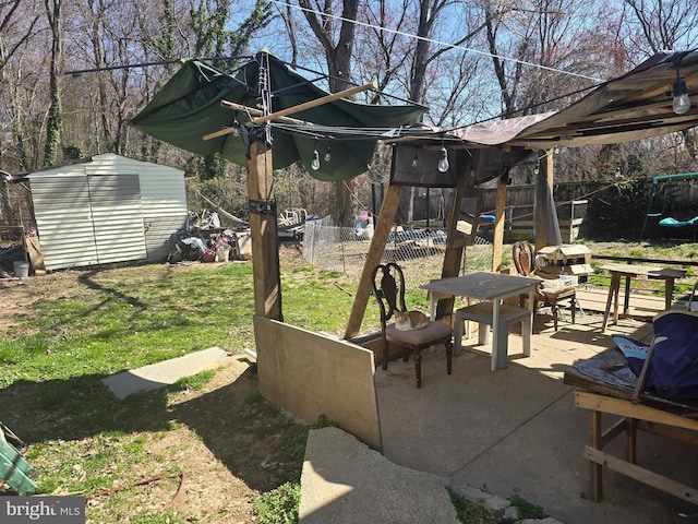 view of patio / terrace with an outdoor structure, fence, and a shed