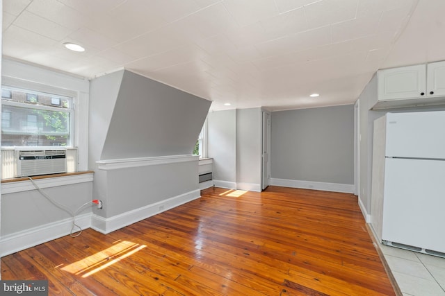 interior space featuring baseboards, a healthy amount of sunlight, and hardwood / wood-style flooring