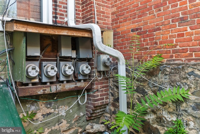 exterior details featuring brick siding and electric meter