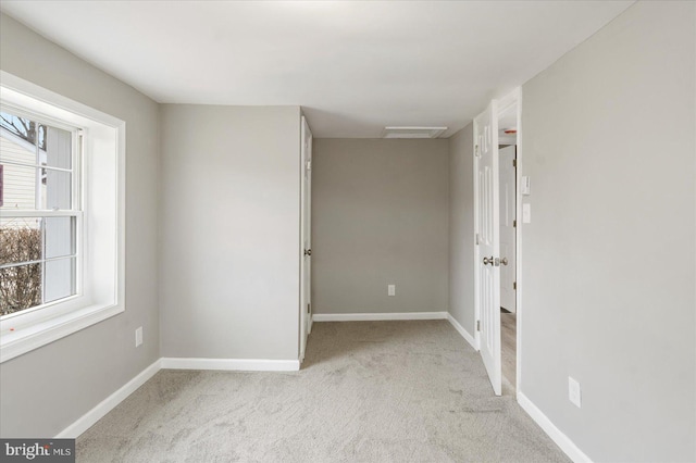 unfurnished room with light carpet, visible vents, and baseboards