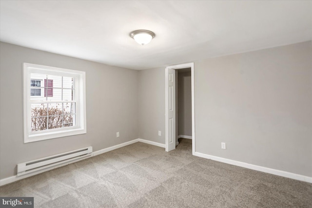 carpeted empty room with a baseboard radiator and baseboards