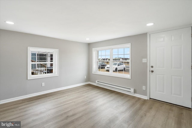 entryway featuring a baseboard radiator, baseboards, wood finished floors, and recessed lighting