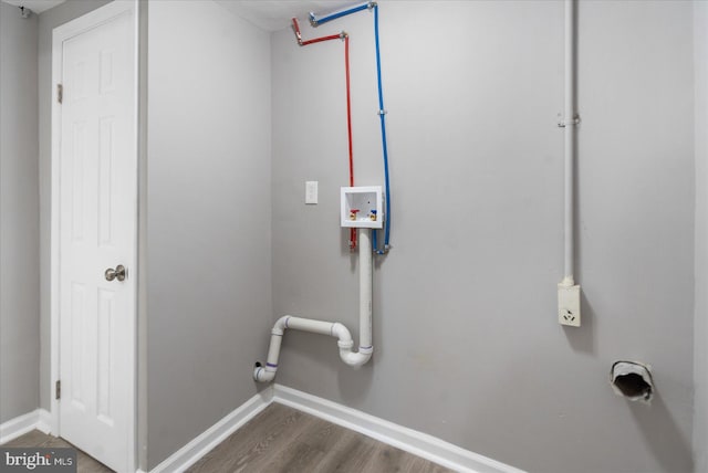 clothes washing area with laundry area, dark wood-type flooring, washer hookup, and baseboards