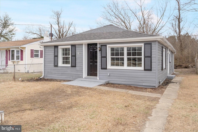 bungalow with a shingled roof and fence