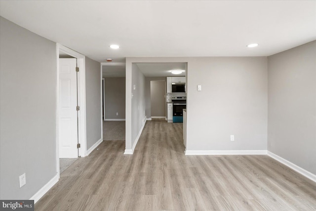 unfurnished room with recessed lighting, light wood-type flooring, and baseboards