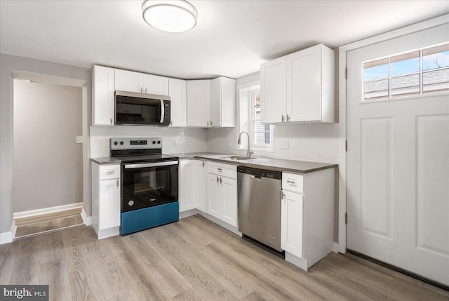 kitchen with light wood finished floors, tasteful backsplash, stainless steel appliances, and a sink