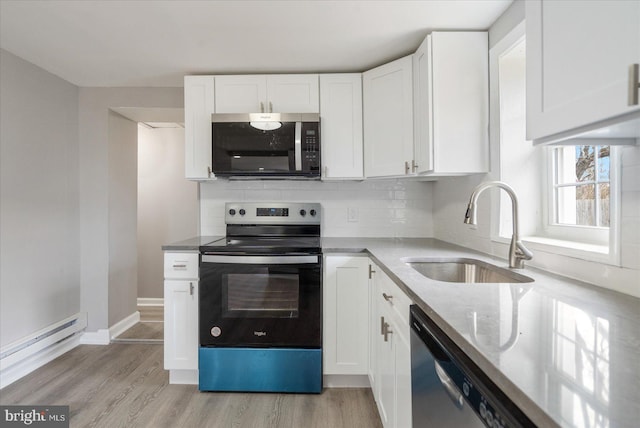 kitchen featuring decorative backsplash, appliances with stainless steel finishes, white cabinetry, a sink, and light stone countertops